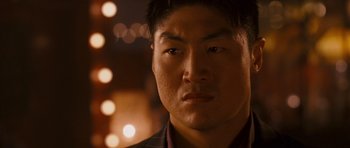 Movie still from “The Fast and the Furious: Tokyo Drift” (2006), directed by Justin Lin – A man's face in front of lights; Close Up shot, Low angle