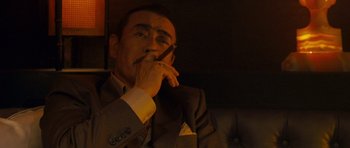 Movie still from “The Fast and the Furious: Tokyo Drift” (2006), directed by Justin Lin – A man smoking a cigarette while holding a cell phone to his ear; Close Up shot, Low angle