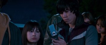 Movie still from “The Fast and the Furious: Tokyo Drift” (2006), directed by Justin Lin – A man and a woman looking at a cell phone; Close Up shot, Low angle