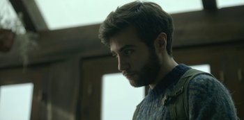 Movie still from “The Girl in the Mirror” (2022), created by Sergio G. Sánchez – A person with a beard looking to his left; Close Up shot, Low angle