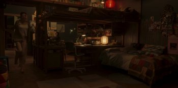 Movie still from “The Girl in the Mirror” (2022), created by Sergio G. Sánchez – A room with a desk and a bed in it; Wide shot, High angle