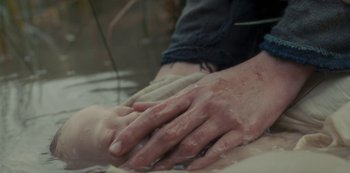 Movie still from “The Girl in the Mirror” (2022), created by Sergio G. Sánchez – A person with their hands covered in mud; Extreme Close Up shot, High angle