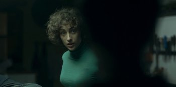 Movie still from “The Girl in the Mirror” (2022), created by Sergio G. Sánchez – A woman with curly brown hair wearing a green shirt; Close Up shot, Over the shoulder angle