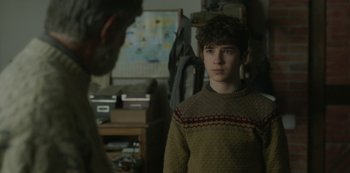 Movie still from “The Girl in the Mirror” (2022), created by Sergio G. Sánchez – A young man standing in front of an older man; Medium shot, Over the shoulder angle
