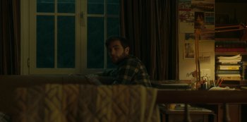 Movie still from “The Girl in the Mirror” (2022), created by Sergio G. Sánchez – A man sitting in front of a window at night; Medium shot, Over the shoulder angle