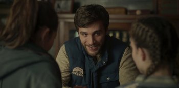 Movie still from “The Girl in the Mirror” (2022), created by Sergio G. Sánchez – A man sitting at a table talking to two other people; Close Up shot, Over the shoulder angle