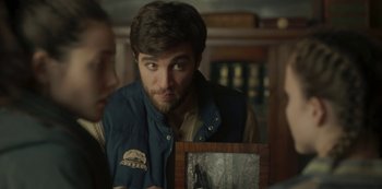 Movie still from “The Girl in the Mirror” (2022), created by Sergio G. Sánchez – A man looking at a picture of a bear in a room; Close Up shot, Over the shoulder angle