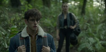 Movie still from “The Girl in the Mirror” (2022), created by Sergio G. Sánchez – A man and a woman are walking through the woods; Medium shot, Over the shoulder angle