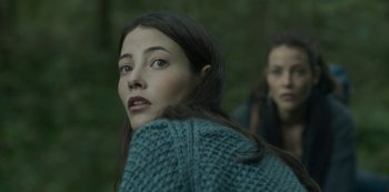 Movie still from “The Girl in the Mirror” (2022), created by Sergio G. Sánchez – A woman in a blue sweater looking to her left; Close Up shot, Low angle