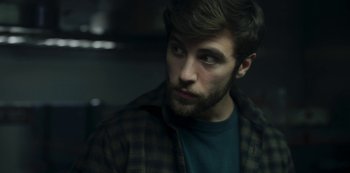 Movie still from “The Girl in the Mirror” (2022), created by Sergio G. Sánchez – A person with a beard looking at the camera; Close Up shot, Low angle