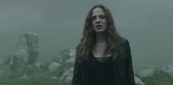 Movie still from “The Girl in the Mirror” (2022), created by Sergio G. Sánchez – A woman with long curly hair standing in the fog; Close Up shot, Low angle