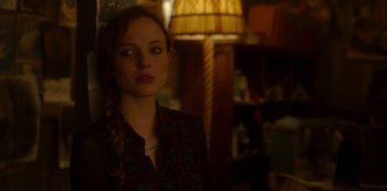 Movie still from “The Girl in the Mirror” (2022), created by Sergio G. Sánchez – A woman standing in front of a lamp in a room; Close Up shot, Over the shoulder angle