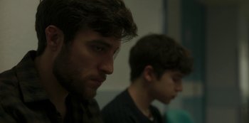 Movie still from “The Girl in the Mirror” (2022), created by Sergio G. Sánchez – Two young men sitting next to each other in a room; Close Up shot, Over the shoulder angle