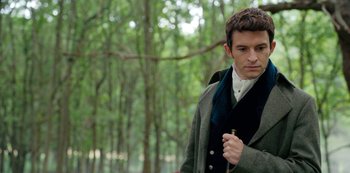 Movie still from “Bridgerton” (2020), created by Chris Van Dusen – A man in a coat and tie standing next to a forest; Close Up shot, Over the shoulder angle