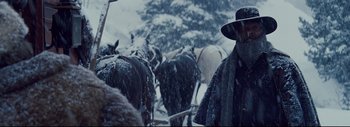 Movie still from “The Hateful Eight” (2015), directed by Quentin Tarantino – A group of horses being herded through the snow; Medium shot, Low angle