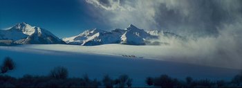 Movie still from “The Hateful Eight” (2015), directed by Quentin Tarantino – A mountain range with a lot of snow on it; Extreme Wide shot, High angle