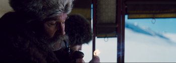 Movie still from “The Hateful Eight” (2015), directed by Quentin Tarantino – An old man with a beard is smoking a pipe; Close Up shot, Low angle
