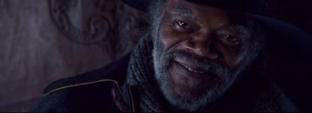 Movie still from “The Hateful Eight” (2015), directed by Quentin Tarantino – An older man with a beard and a hat; Close Up shot, Over the shoulder angle