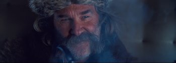 Movie still from “The Hateful Eight” (2015), directed by Quentin Tarantino – A person wearing a hat and smoking a pipe; Close Up shot, Low angle