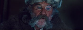 Movie still from “The Hateful Eight” (2015), directed by Quentin Tarantino – An old man with a beard and a fur hat; Close Up shot, Over the shoulder angle