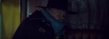 Movie still from “The Hateful Eight” (2015), directed by Quentin Tarantino – A man wearing a hat and a scarf; Close Up shot, Over the shoulder angle