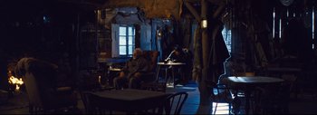 Movie still from “The Hateful Eight” (2015), directed by Quentin Tarantino – Two men sitting in chairs in a room; Wide shot, High angle