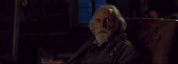 Movie still from “The Hateful Eight” (2015), directed by Quentin Tarantino – An old man with white hair and a white beard; Close Up shot, Over the shoulder angle