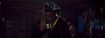 Movie still from “The Hateful Eight” (2015), directed by Quentin Tarantino – A man in a hat and scarf holding a cup of coffee; Close Up shot, Low angle