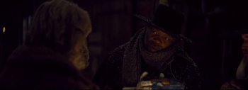 Movie still from “The Hateful Eight” (2015), directed by Quentin Tarantino – A man wearing a black hat and a black scarf; Close Up shot, Over the shoulder angle