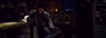 Movie still from “The Hateful Eight” (2015), directed by Quentin Tarantino – An older man sitting in a chair wearing a hat; Medium shot, Low angle
