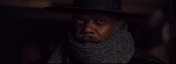 Movie still from “The Hateful Eight” (2015), directed by Quentin Tarantino – A man wearing a black hat and a scarf; Close Up shot, Low angle