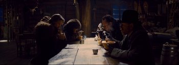 Movie still from “The Hateful Eight” (2015), directed by Quentin Tarantino – A group of people sitting at a table eating soup; Medium shot, High angle