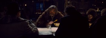 Movie still from “The Hateful Eight” (2015), directed by Quentin Tarantino – An old man sitting at a table with a bowl of food; Medium shot, Over the shoulder angle