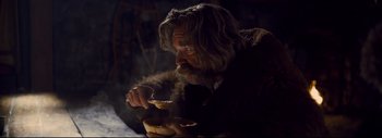 Movie still from “The Hateful Eight” (2015), directed by Quentin Tarantino – An old man with long hair and a beard eating food; Medium shot, Over the shoulder angle