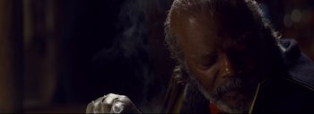Movie still from “The Hateful Eight” (2015), directed by Quentin Tarantino – An old man smoking a cigarette in the dark; Extreme Close Up shot, Low angle