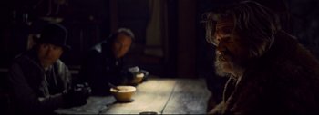 Movie still from “The Hateful Eight” (2015), directed by Quentin Tarantino – Two people sitting at a table with a bowl of soup; Medium shot, Over the shoulder angle