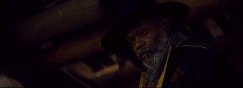 Movie still from “The Hateful Eight” (2015), directed by Quentin Tarantino – An older man wearing a black hat and a yellow vest; Close Up shot, Low angle