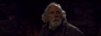 Movie still from “The Hateful Eight” (2015), directed by Quentin Tarantino – An old man with a beard and a white beard; Close Up shot, Over the shoulder angle