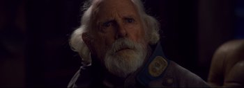 Movie still from “The Hateful Eight” (2015), directed by Quentin Tarantino – An old man with a white beard is looking at the camera; Close Up shot, Over the shoulder angle