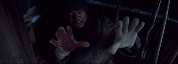Movie still from “The Hateful Eight” (2015), directed by Quentin Tarantino – A man in a sweater and hat holding a bloody hand; Extreme Close Up shot, Overhead angle