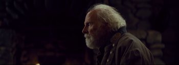 Movie still from “The Hateful Eight” (2015), directed by Quentin Tarantino – An old man with a white beard looking to his left; Close Up shot, Over the shoulder angle