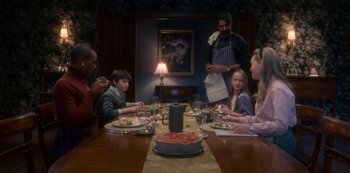 Movie still from “The Haunting of Bly Manor” (2020), directed by E.L. Katz – A group of people sitting around a table eating food; Medium shot, High angle