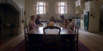 Movie still from “The Haunting of Bly Manor” (2020), directed by E.L. Katz – A group of people sitting around a table eating food; Wide shot, High angle
