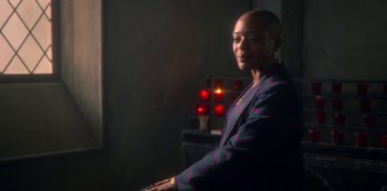 Movie still from “The Haunting of Bly Manor” (2020), directed by E.L. Katz – A woman in a purple jacket is standing in front of a red light; Medium shot, Over the shoulder angle