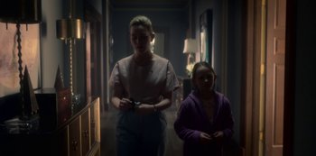 Movie still from “The Haunting of Bly Manor” (2020), directed by E.L. Katz – A woman and a girl walking down a hall way; Medium shot, Low angle