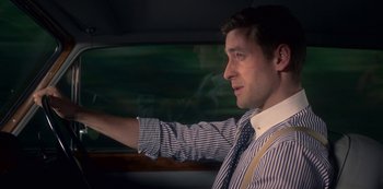 Movie still from “The Haunting of Bly Manor” (2020), directed by E.L. Katz – A man in a suit and tie driving a car; Close Up shot, Over the shoulder angle
