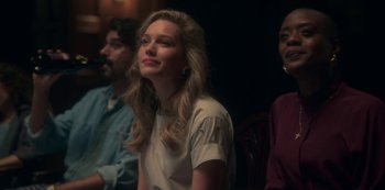 Movie still from “The Haunting of Bly Manor” (2020), directed by E.L. Katz – A woman sitting next to two other people in a room; Medium shot, Over the shoulder angle
