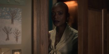 Movie still from “The Haunting of Bly Manor” (2020), directed by E.L. Katz – A woman standing in front of a door looking at the camera; Close Up shot, Over the shoulder angle