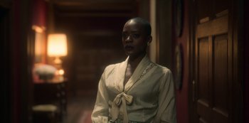 Movie still from “The Haunting of Bly Manor” (2020), directed by E.L. Katz – A woman standing in front of a wall; Medium shot, Over the shoulder angle