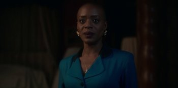 Movie still from “The Haunting of Bly Manor” (2020), directed by E.L. Katz – A woman in a blue jacket standing in the dark; Close Up shot, Over the shoulder angle